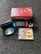 For sale Nintendo Switch V2 console with Joy-Con controls and 2 games, USD 195